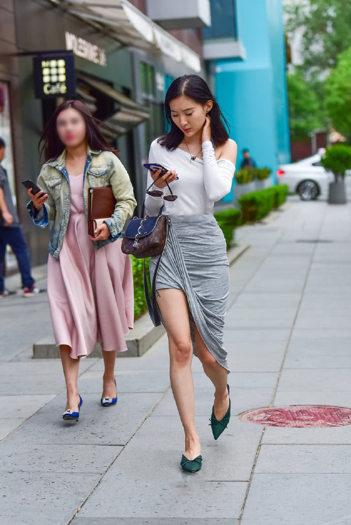 小姐姐太会穿，过膝的长裙将一边的裙角向上翻，是在故意秀美腿吗