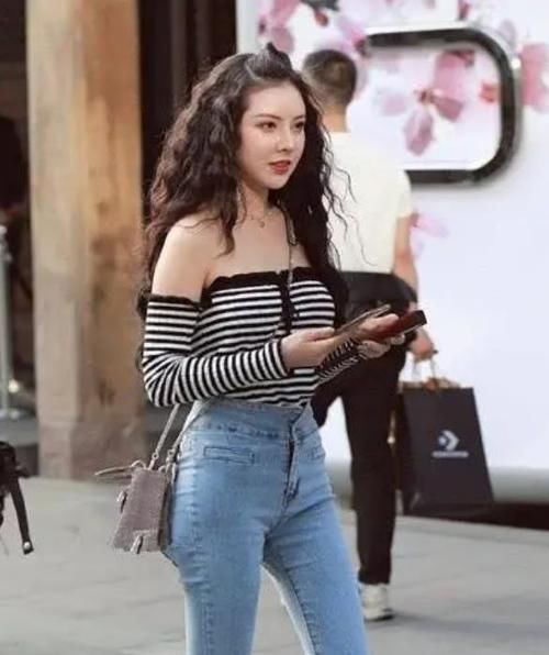  #艳若桃李#潮范儿女神来了，街拍：艳若桃李的美女，一件一字肩上衣配浅色牛仔裤，青春活力范