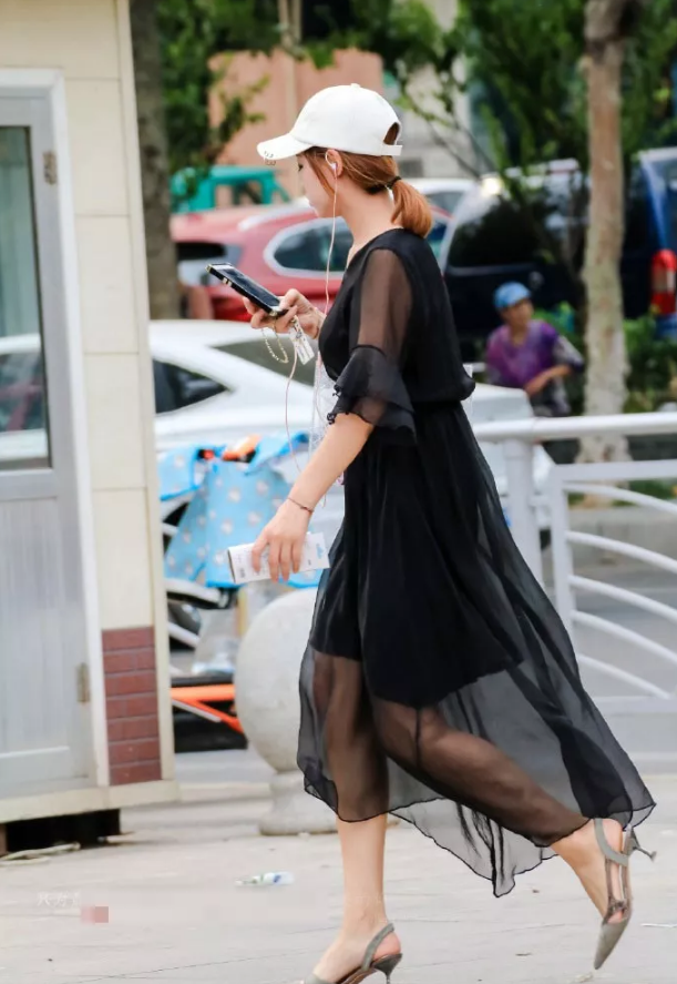 街拍头戴遮阳帽身穿黑色薄纱连衣裙的美女小姐姐