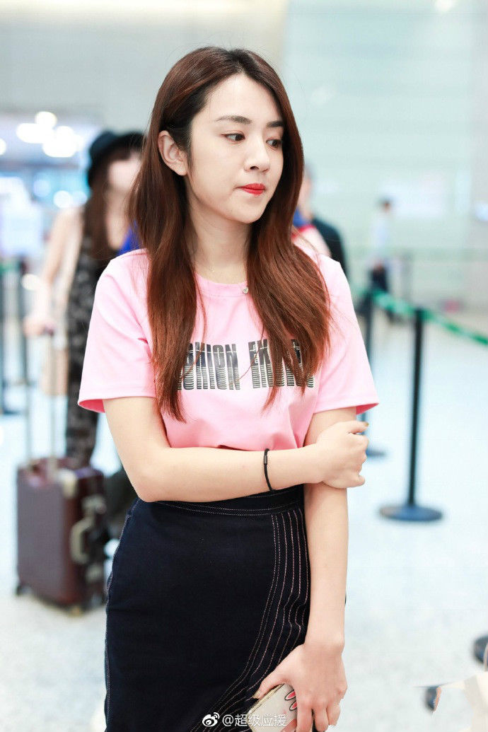 王晓晨穿粉色T恤搭配黑色荷叶边半身裙现身机场，少女感十足