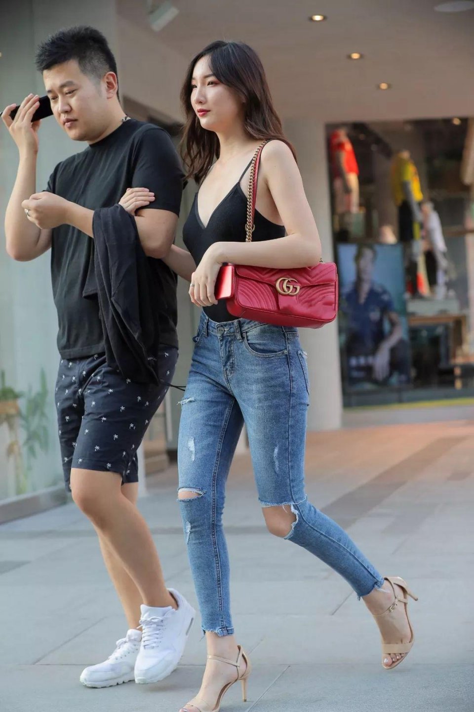 黑色低胸吊带背心搭配蓝色牛仔紧身长裤，悠然洒脱羡煞旁人