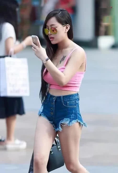 气质小姐姐短裤背心清凉出街，俏皮可爱伸舌头降温，胸口纹身很是
