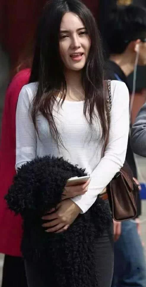 气质小姐姐丰腴甜美，轻轻一撩秀发，走起路来左右摇摆很不方便