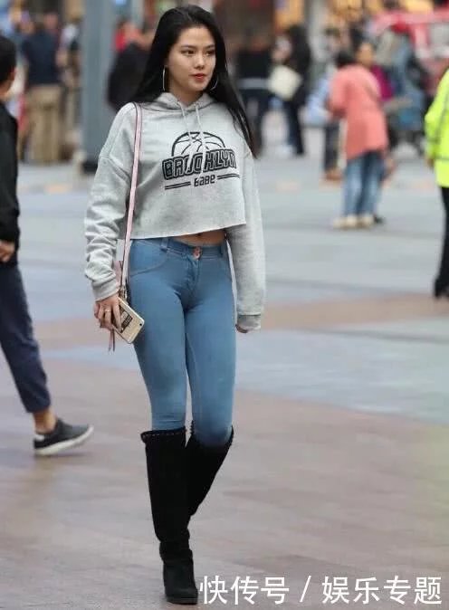 气质女孩紧身牛仔裤搭配酷酷的黑色长靴，秀出玲珑有致好身材