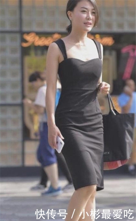 美女：美女穿着一身黑色的连衣裙，散发着一种成熟的美感与气质，街拍