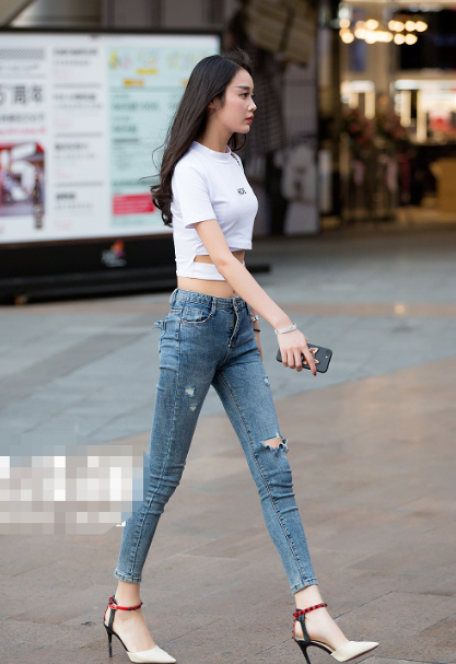 街拍：小姐姐上衣是露肚脐的设计，秀出平坦的小腹，十分性感！