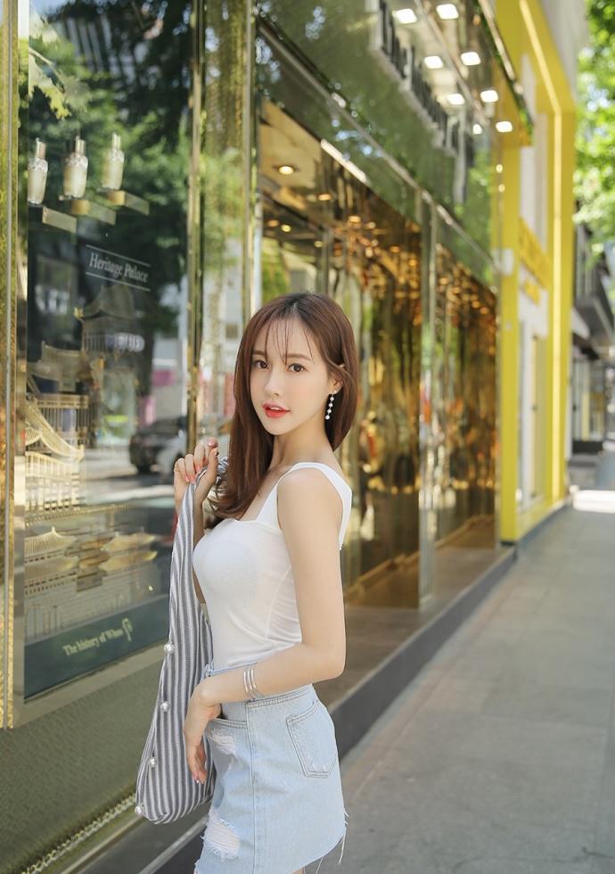 路人街拍,小姐姐牛仔短裙搭配白色吊带衫,简直是甜美到没朋友