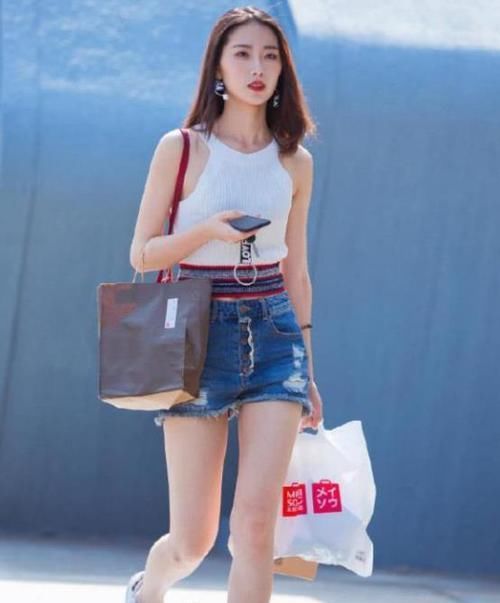  「休闲裤」街拍：身材高挑的美女，一件米黄色上衣配橘红色休闲裤，气质十足