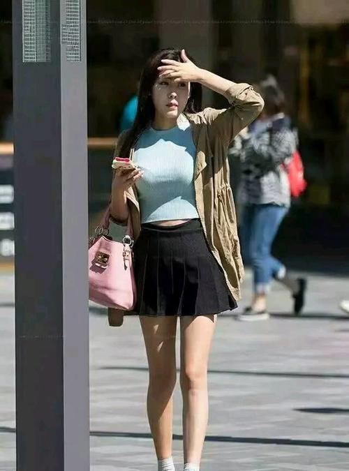 街拍，美女一身橙色性感紧身裙子，身材丰满，迎面走来，漂亮妩媚