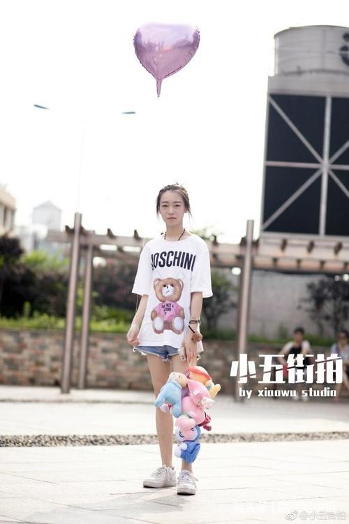 路人街拍:白T恤+印花吊带裙,再加一把红雨伞,小姐姐很美