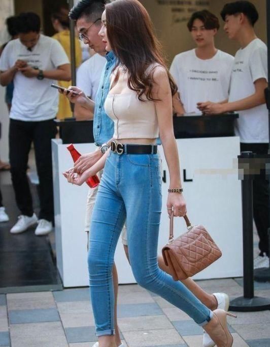 『长袖』街拍小姐姐白色的长袖T恤搭配蓝色牛仔热裤,时髦靓丽