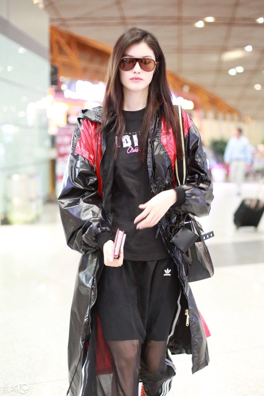 超模何穗现身北京机场，一身雨衣，难掩美腿