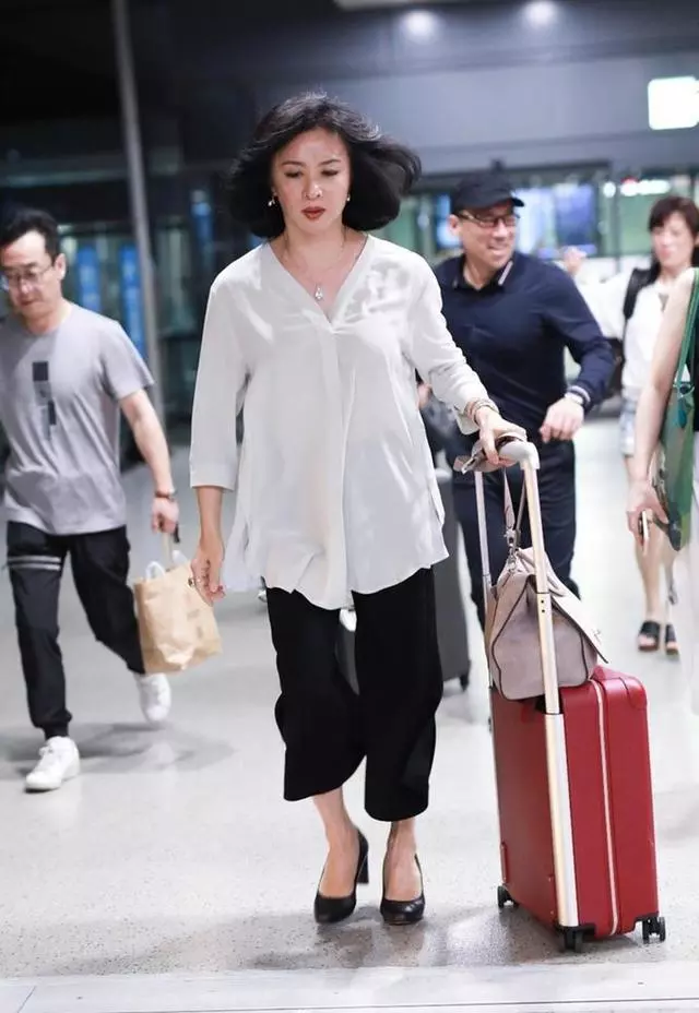 金星现身机场,只穿白衣黑裤竟如此惊艳,50岁越来越有女人味!