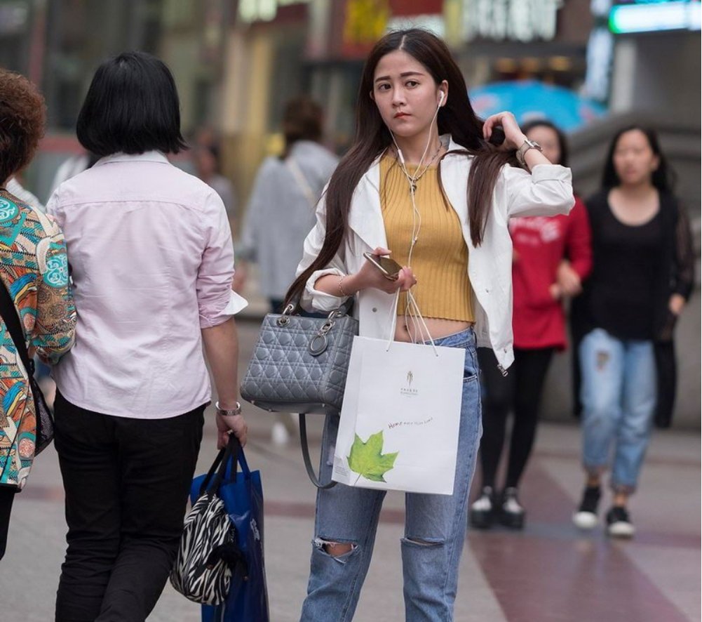 街拍的牛仔裤露脐装长发美女