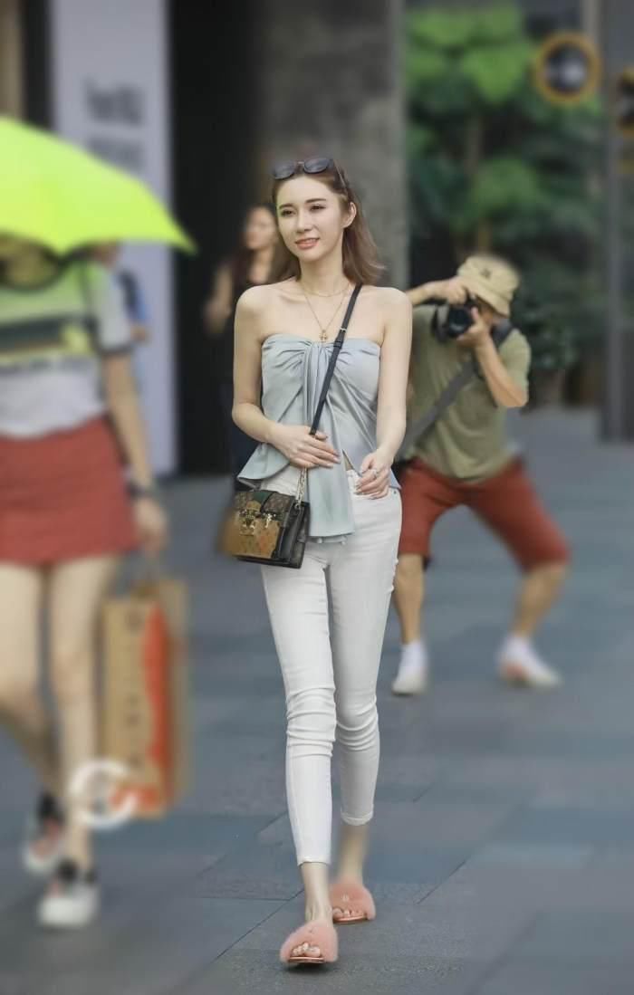 美女淡蓝色露肩的抹胸上衣真是好看，只是现身紧身牛仔裤有点尴尬