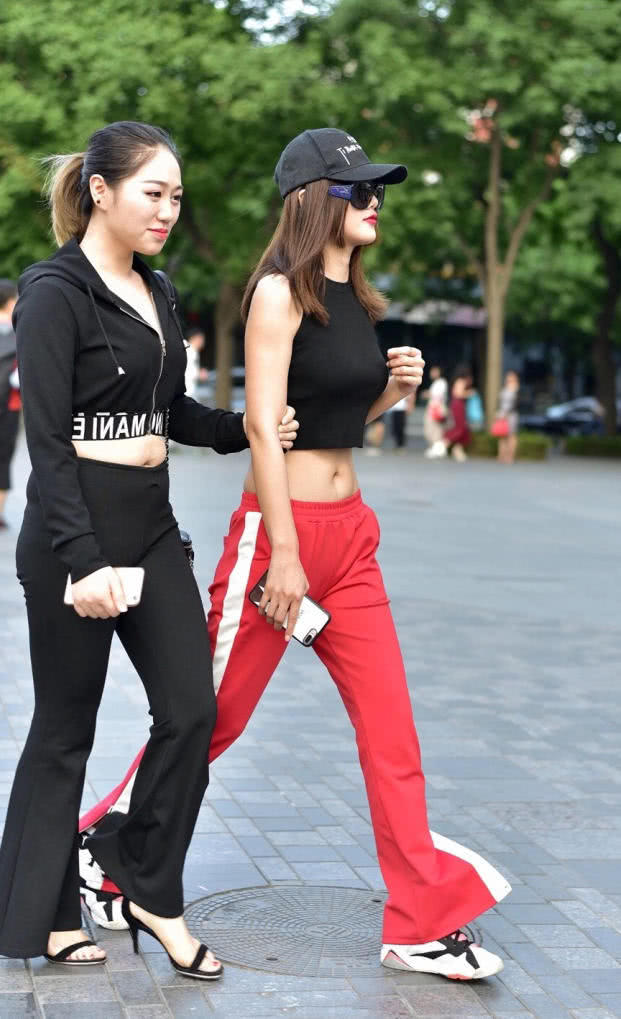 小姐姐紧身露脐装勾勒出丰满上围，平底鞋的穿搭，仍然比闺蜜高出