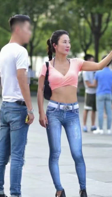 风韵小姐姐穿着牛仔紧身裤尽显玲珑曲线，白色腰带搭配的很亮眼