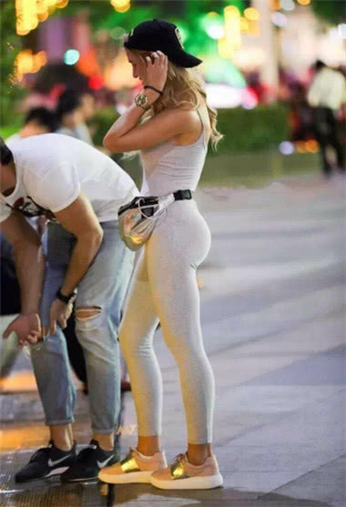 小姐姐白色紧身裤勾勒奥妙的圆润线条，夜色下朦胧可人