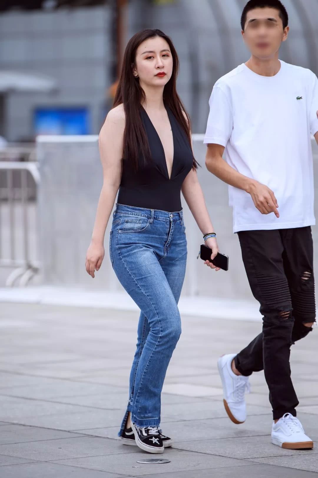 小姐姐黑色中开吊带搭配蓝色水洗牛仔裤，自信舞步风韵尚存