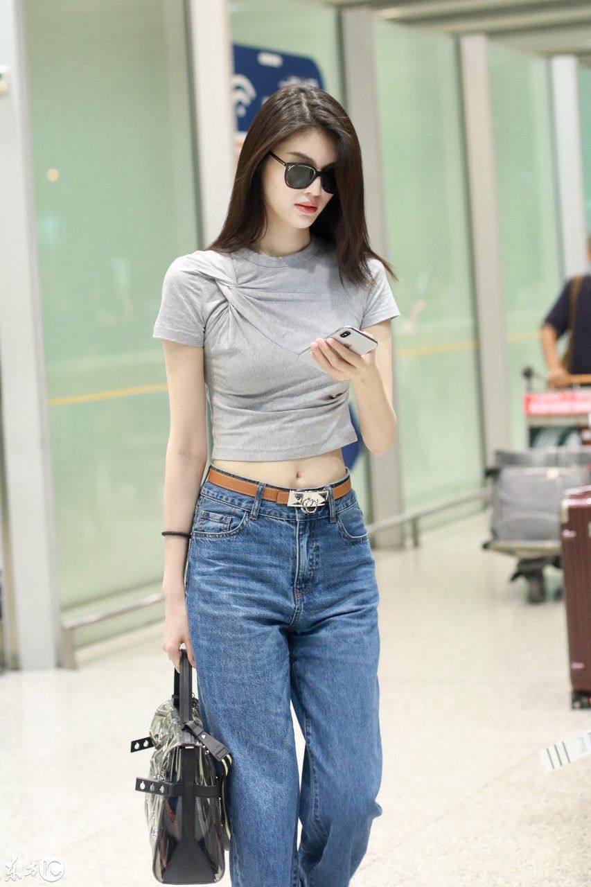 何穗戴墨镜穿灰色T恤搭配蓝色牛仔裤现身机场，皮肤白皙秀大长腿