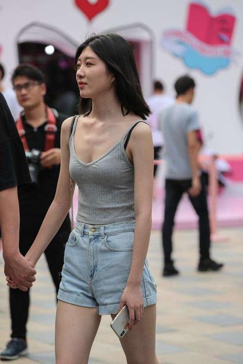 街拍：情侣牵手上街，女友吊带上衣性感十足，路人都忍不住多看！