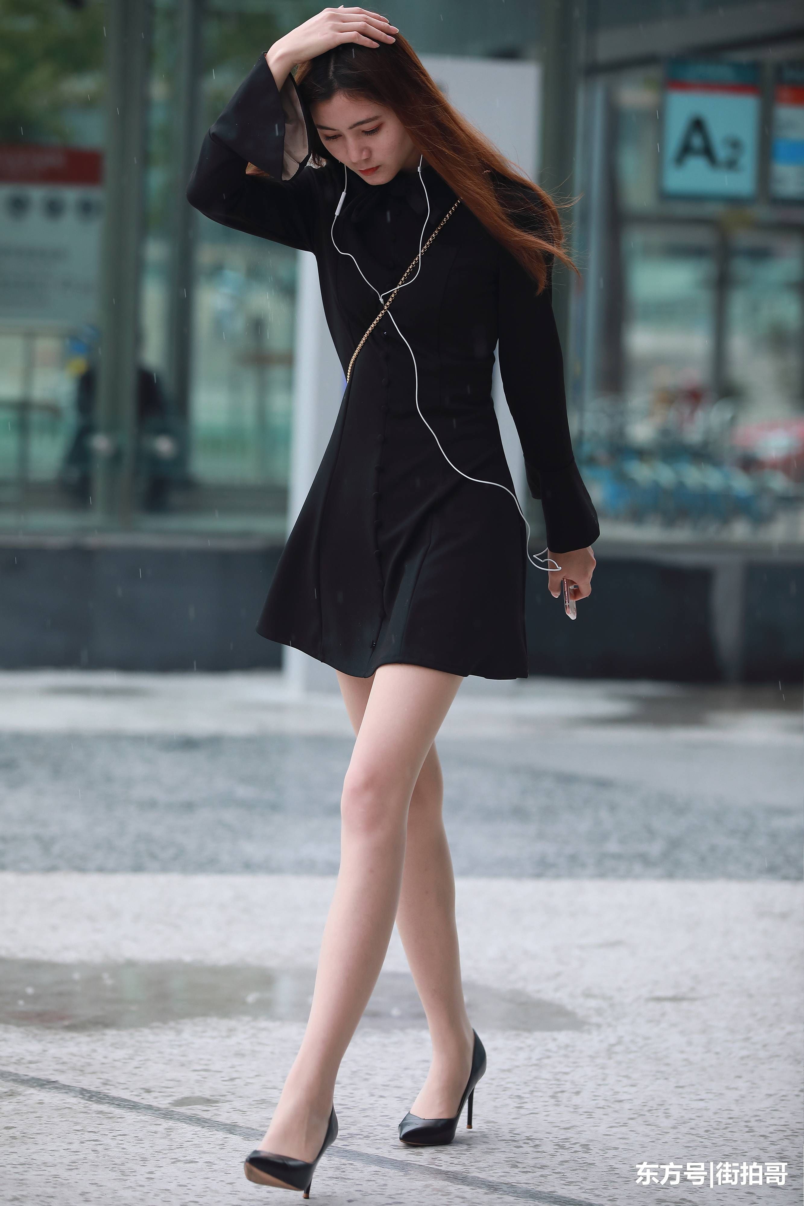 街拍联盟:雨中漫步的肉丝美女,连衣短裙配高跟彰显女神风范