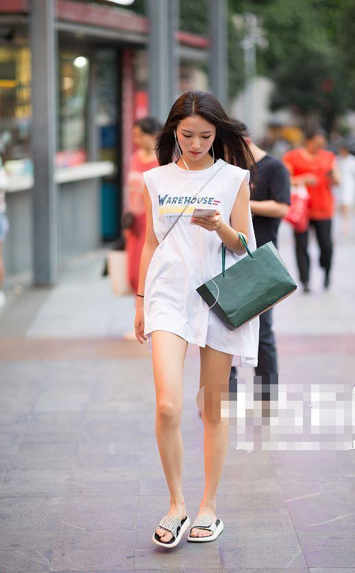 路人街拍，不规则的短裙勾勒出了小姐姐的玲珑曲线，很是性感