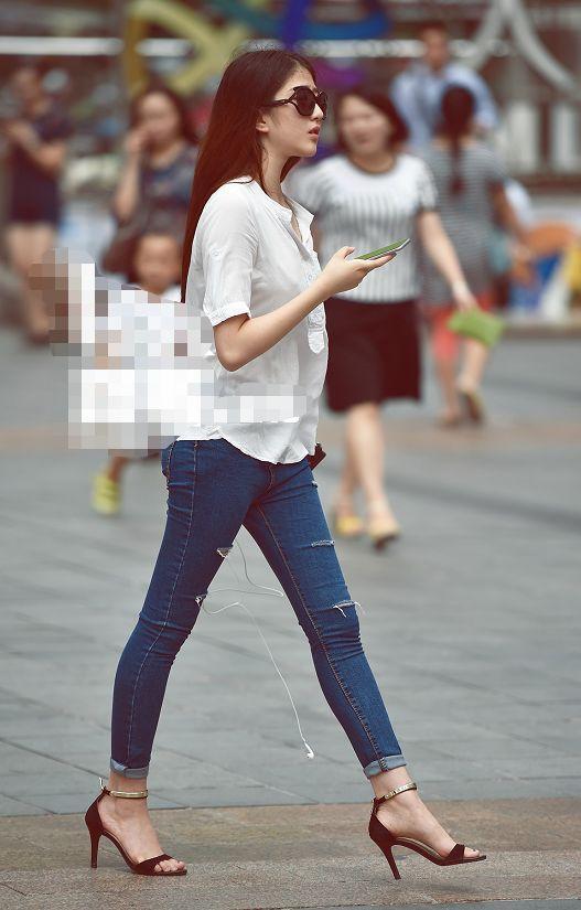 路人街拍，小姐姐身穿小吊带，露出性感的小蛮腰，很是清新迷人