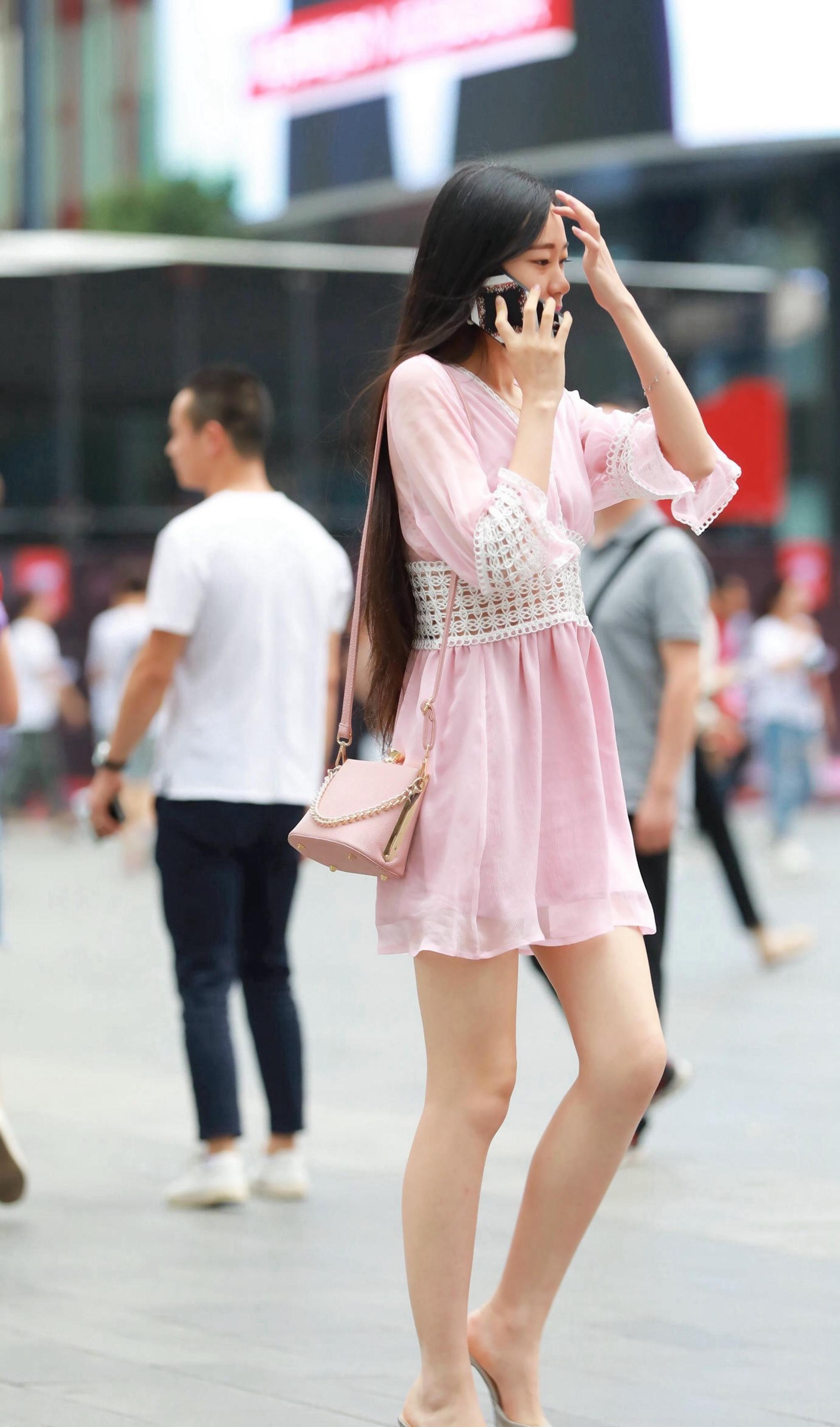 美女:穿着粉色连衣裙的美女,纤细白净的大长腿,真是惹人羡慕