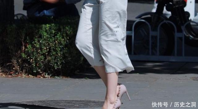 脚踩一双铆钉裸色高跟鞋，配上一袭长裙秀出女人柔和之美