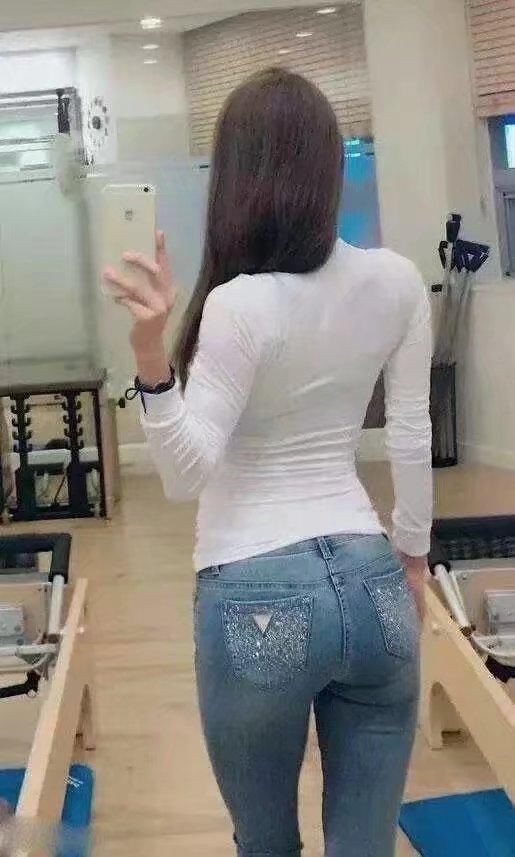 长发美女紧身牛仔裤搭配黑色吊带，娇俏的容颜，气质甜美