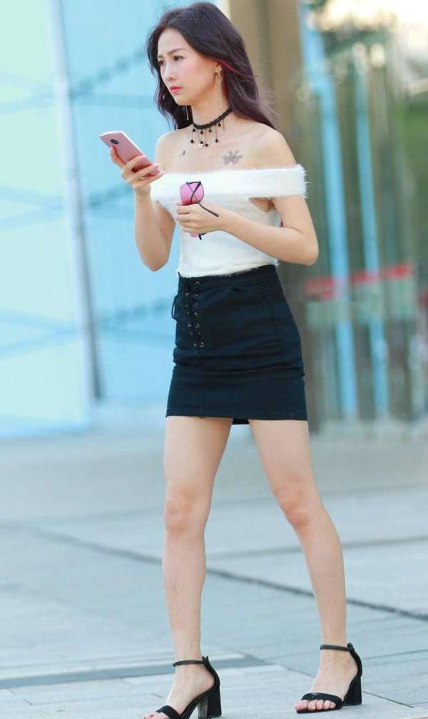 街拍，穿着齐肩短上衣配一步裙的小姐姐，长腿白皙如玉！