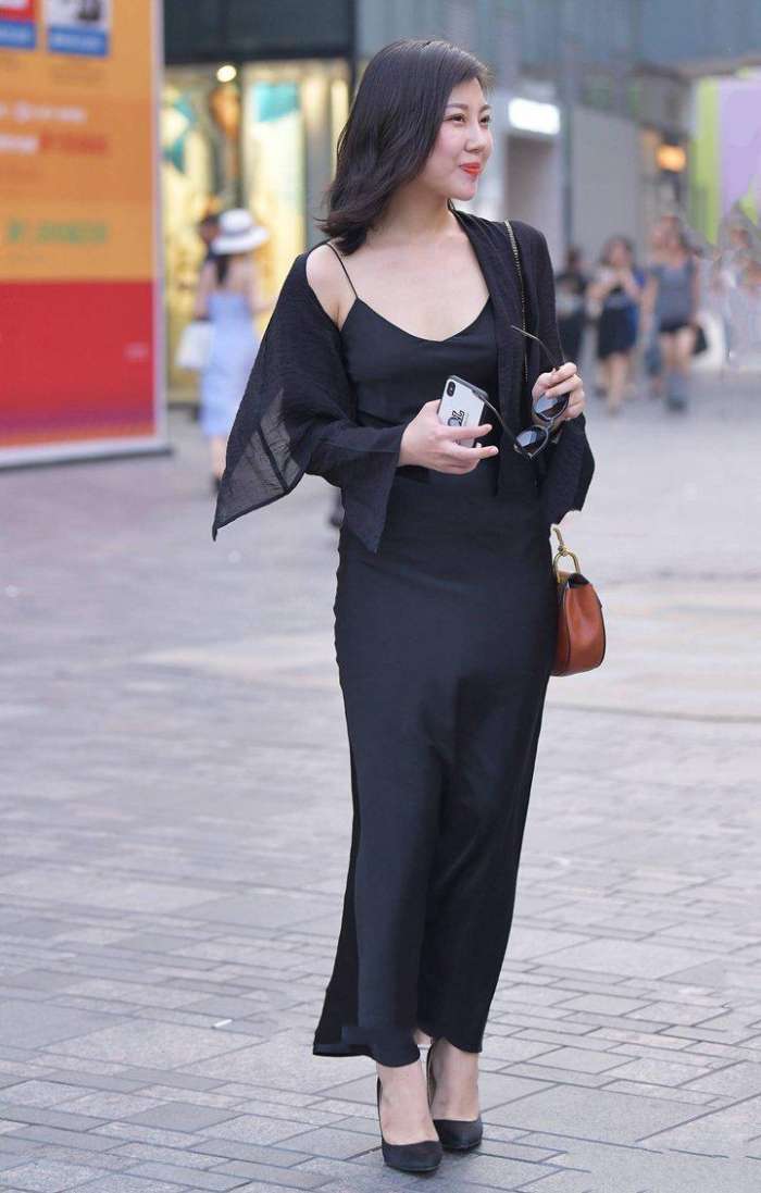 美女深色打扮, 透露出婀娜多姿的身段, 举手投足尽显魅力