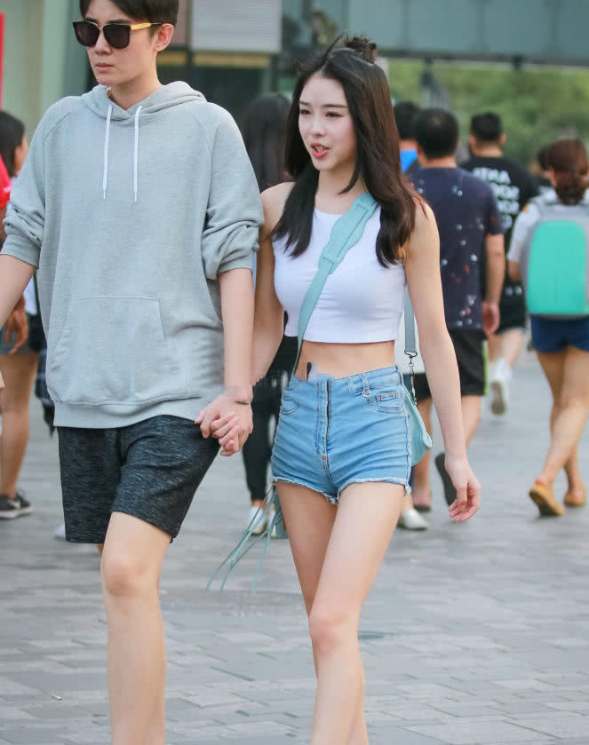 甜美小姐姐露脐装秀出白皙小蛮腰，超短裤裹出浑圆曲线，丸子头俏