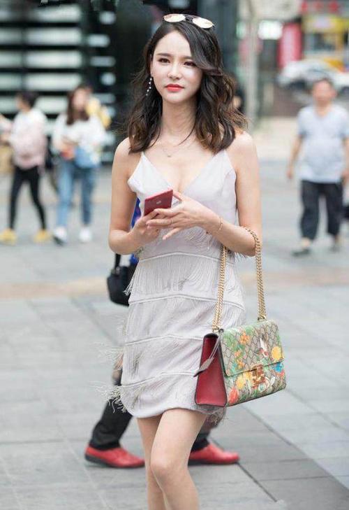 路人街拍，小姐姐身穿黑色牛仔短裤，看上去充满青春活力