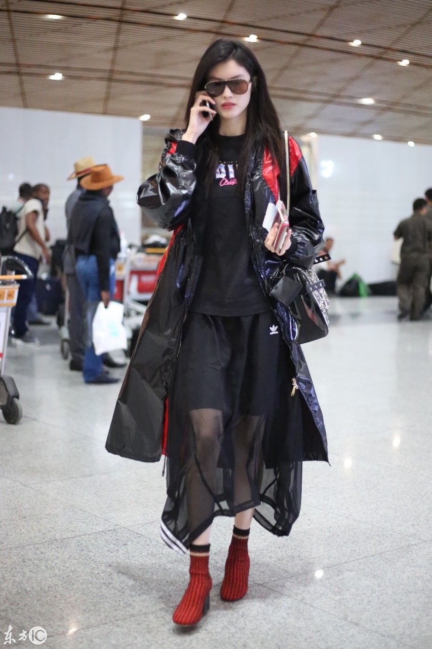 超模何穗现身北京机场，一身雨衣，难掩美腿