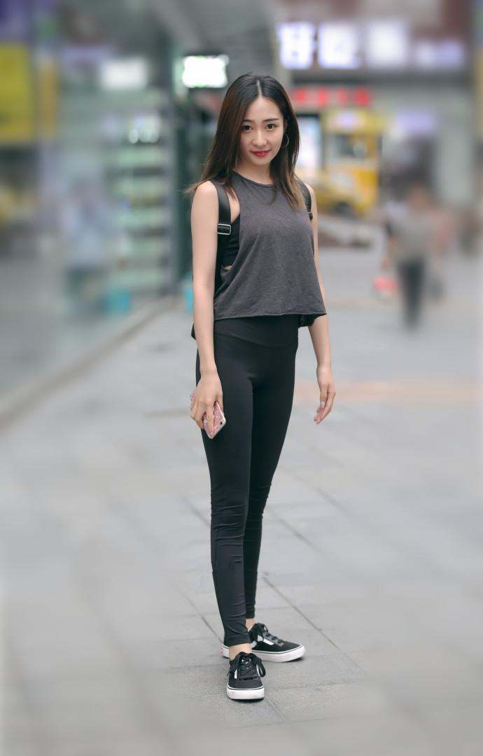 街拍：气质小姐姐紧身牛仔裤搭粉色吊带上衣凸显好身材，打扮迷人