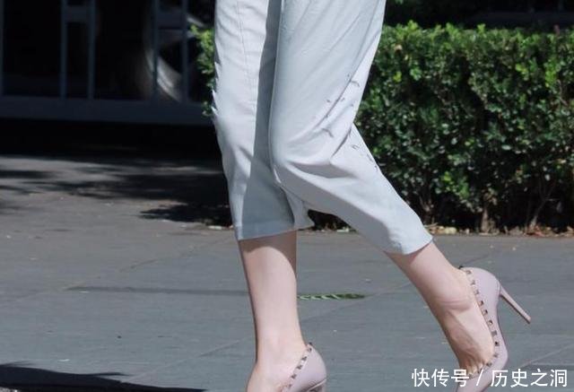 脚踩一双铆钉裸色高跟鞋，配上一袭长裙秀出女人柔和之美