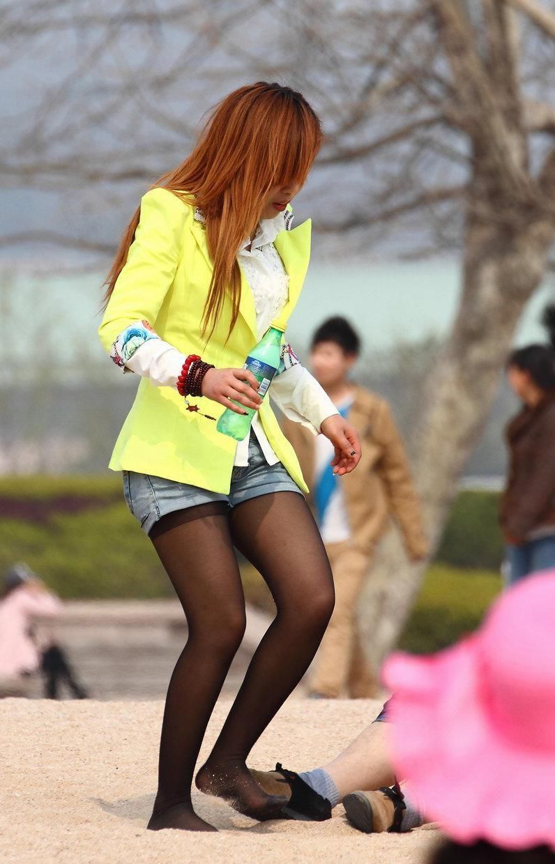 街拍:阳光沙滩上蹲姿曼妙的美女，细腻的黑丝更加灵动