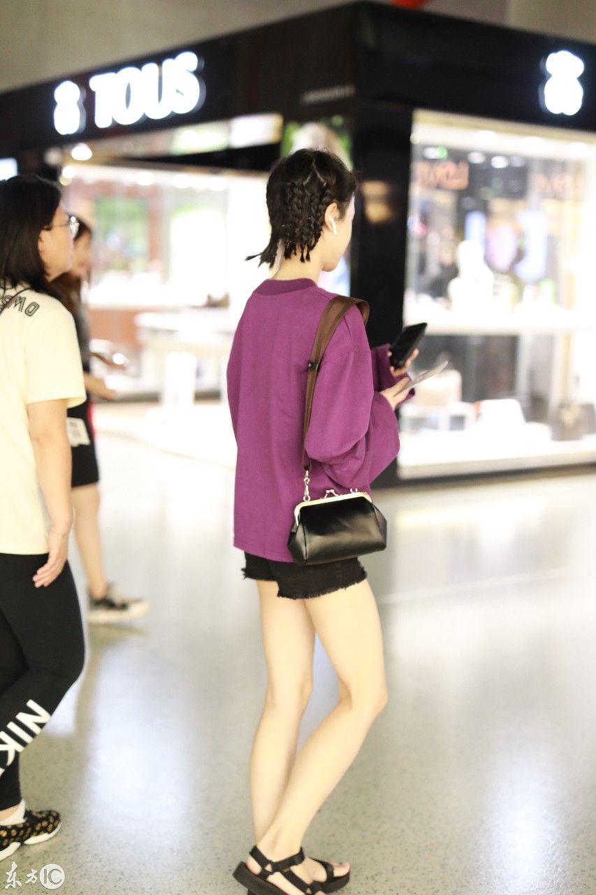姜梓新穿紫色卫衣搭配黑短裤现身机场，皮肤白皙面带微笑大秀美腿