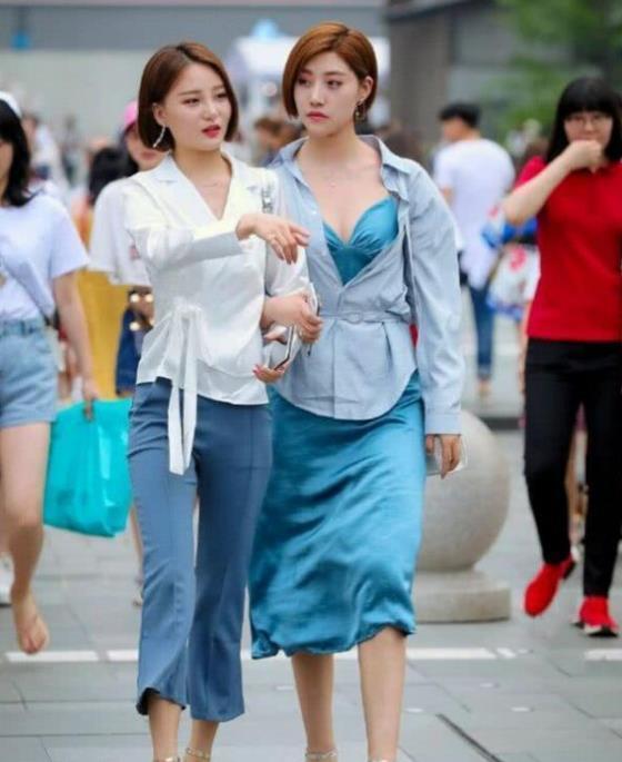  蓝色：街拍：亭亭玉立的美女，一件蓝色的连体长裤，尽显完美好身材