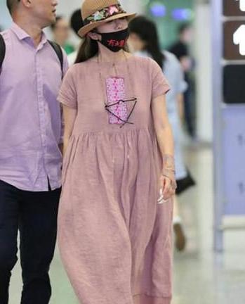 60岁杨丽萍真疯狂，穿20岁的衣服走机场，网友：口罩上的字亮了