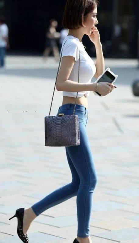 蘑菇头小姐姐浅蓝色潮修身牛仔裤裹出丰满的臀线，羞涩感让人吸睛