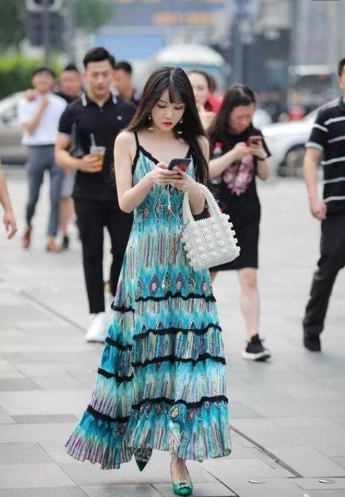 街拍：婴儿肥小姐姐孔雀翎吊带裙显出完美身姿，令人难以移开目光