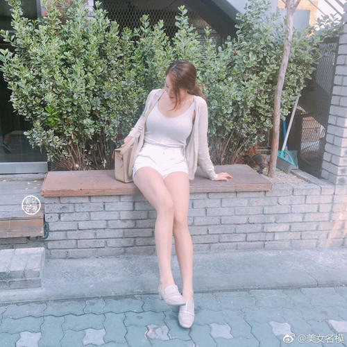 路人街拍，白色上衣搭配白色热裤，展示性感身材，时尚潮流有魅力