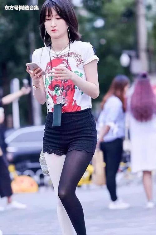 街拍：气质小姐姐高挑热裤显苗条修长双腿，黑白丝袜非常有个性