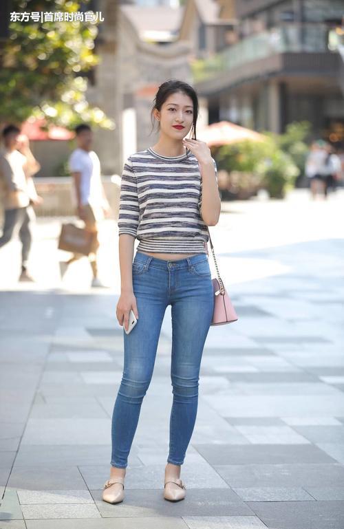 路人街拍：时尚小姐姐紧身牛仔裤勾勒修长美腿，彰显女神气质！