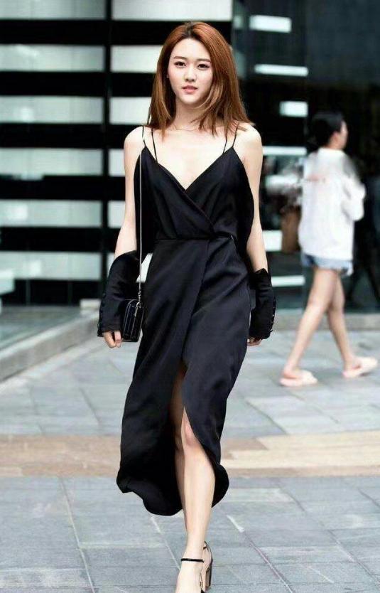 路人街拍，小姐姐上身穿的是一件无袖的露脐紧身上衣，身材真好看