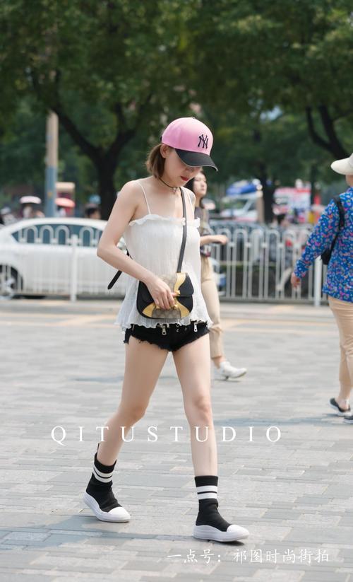 北京街拍：小姐姐身穿黑色性感热裤，头戴粉色棒球帽，个性十足。