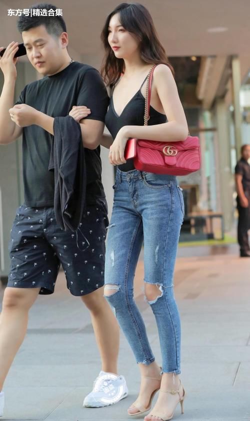 街拍美女：蓝色紧身牛仔裤搭配黑色吊带装，小姐姐身材很好
